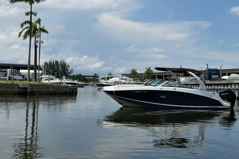 Slide: The Image of 2023 Four Winns HD5 OB boat docked in a marina under a cloudy sky. - 8