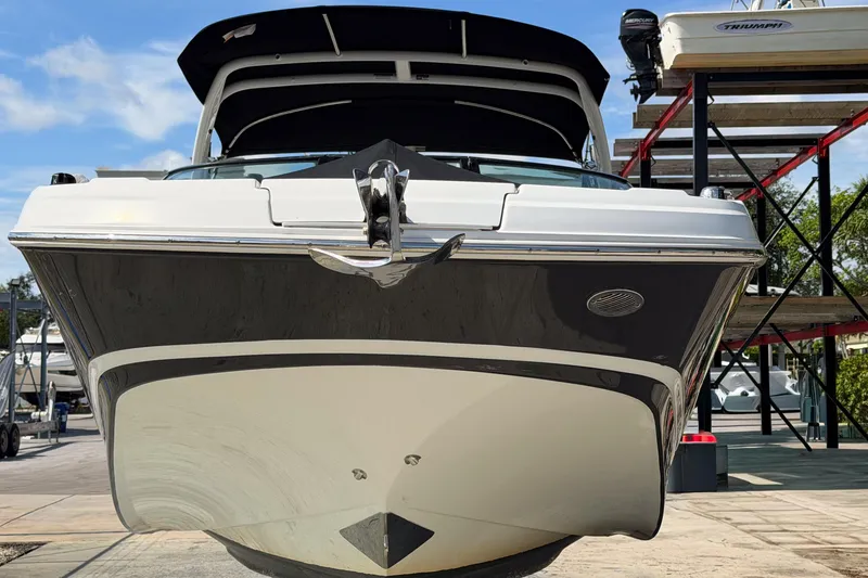 Slide: The Image of 2023 Four Winns HD5 OB boat, docked, front view with clear sky background. - 1