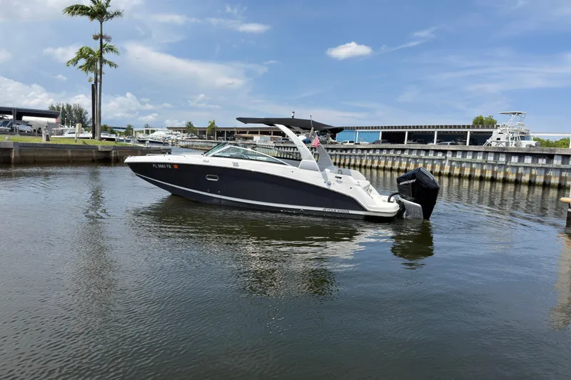 Slide: The Image of 2023 Four Winns HD5 OB boat docked in a marina under a clear blue sky. - 15