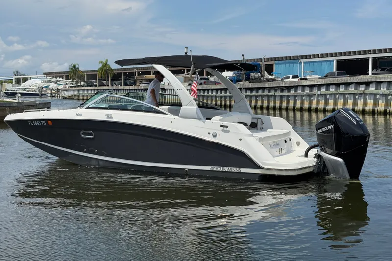 Slide: The Image of 2023 Four Winns HD5 OB boat on water, featuring sleek design and Mercury outboard engine. - 14
