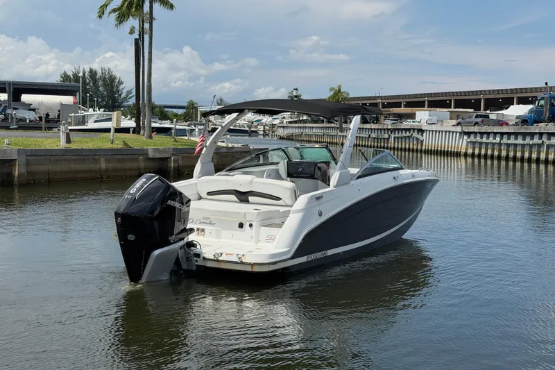Slide: The Image of 2023 Four Winns HD5 OB boat docked in a marina, featuring sleek design and powerful outboard motor. - 12