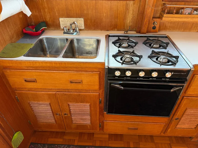 Slide: The Image of The yacht's kitchen features a double sink and stainless steel gas stove. - 17