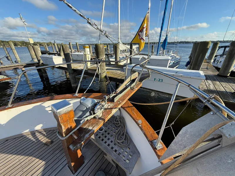 Slide: The Image of A 1981 Marine Trader Double Cabin docked at a wooden pier. Other boats are visible in the background. - 16