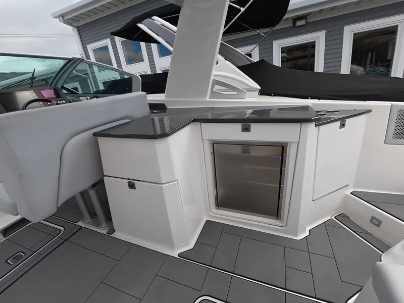 Slide: The Image of The 2021 Aviara AV32 OB features a sleek kitchenette with a fridge and gray countertops. - 10
