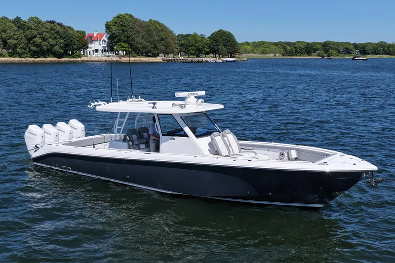 Slide: The Image of 2026 Everglades 395 Center Console boat cruising on a serene lake with scenic background. - 10