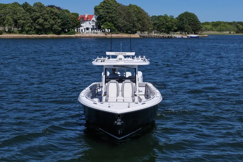 Slide: The Image of 2026 Everglades 395 Center Console boat on water near scenic shoreline. - 12