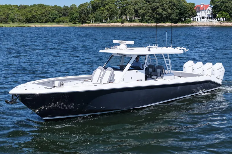 Slide: The Image of 2026 Everglades 395 Center Console boat cruising on a scenic lake. - 2
