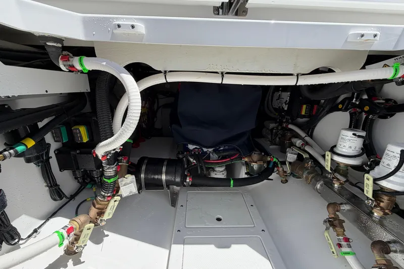 Slide: The Image of Engine compartment of 2026 Everglades 395 Center Console boat, showcasing intricate wiring and plumbing. - 27