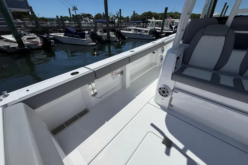 Slide: The Image of 2026 Everglades 395 Center Console boat interior at marina, featuring seating and storage. - 32