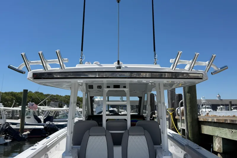 Slide: The Image of 2026 Everglades 395 Center Console boat docked, showcasing seating and rod holders. - 35