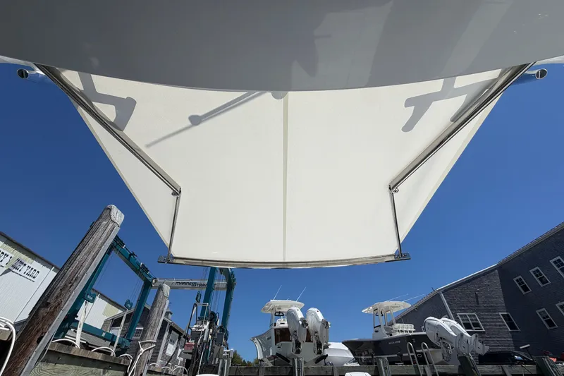 Slide: The Image of 2026 Everglades 395 Center Console boat with sunshade, docked under clear blue sky. - 37