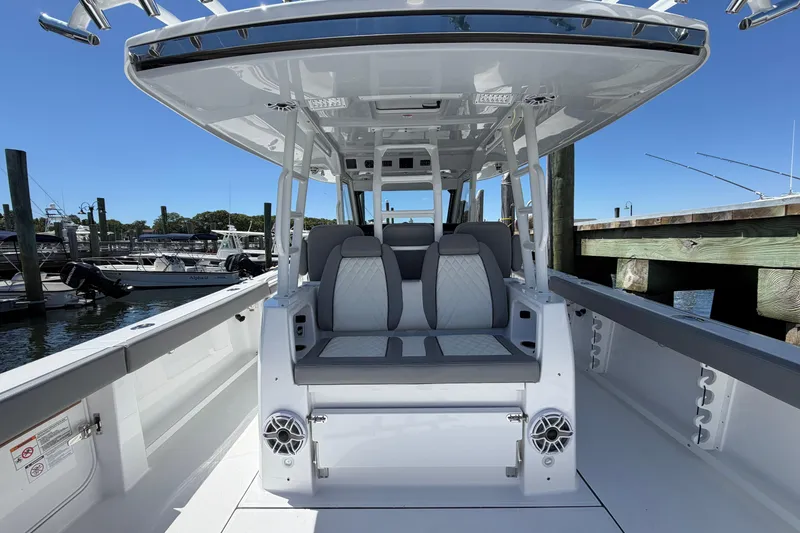 Slide: The Image of 2026 Everglades 395 Center Console boat interior with seating and speakers at a marina. - 38