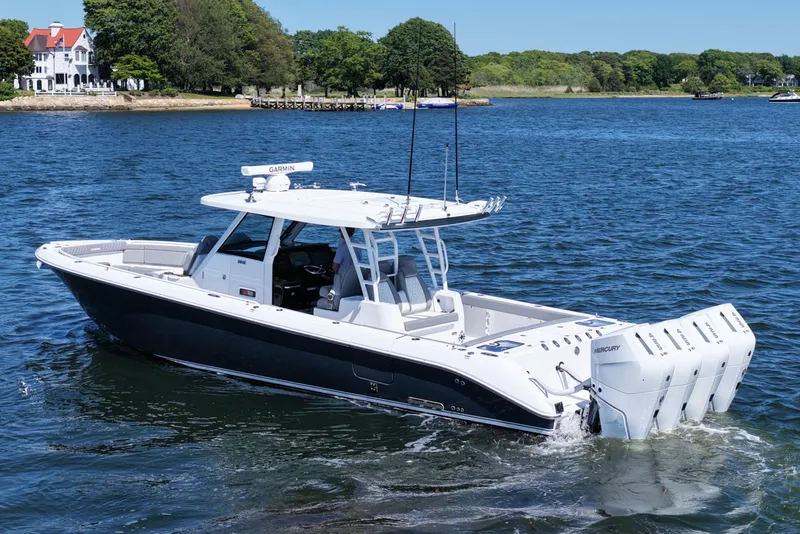 Slide: The Image of 2026 Everglades 395 Center Console boat cruising on a scenic lake. - 4