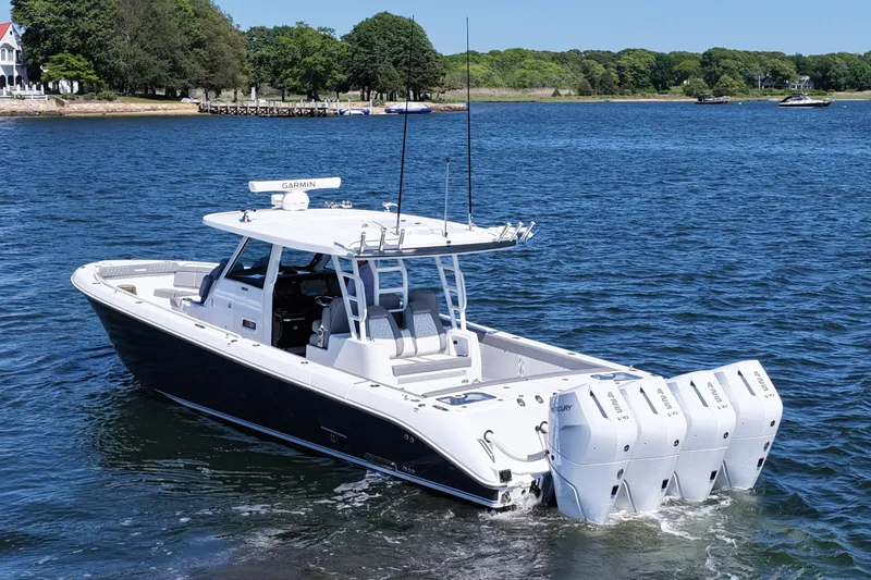 Slide: The Image of 2026 Everglades 395 Center Console boat with quad engines on a serene lake. - 5