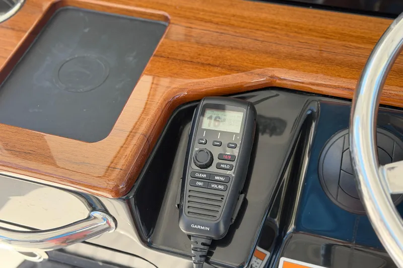 Slide: The Image of Garmin marine radio on 2026 Everglades 395 Center Console's polished wooden dashboard. - 59