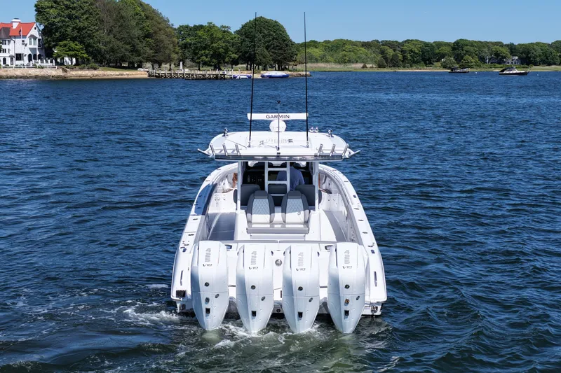 Slide: The Image of 2026 Everglades 395 Center Console boat cruising on a serene lake. - 6