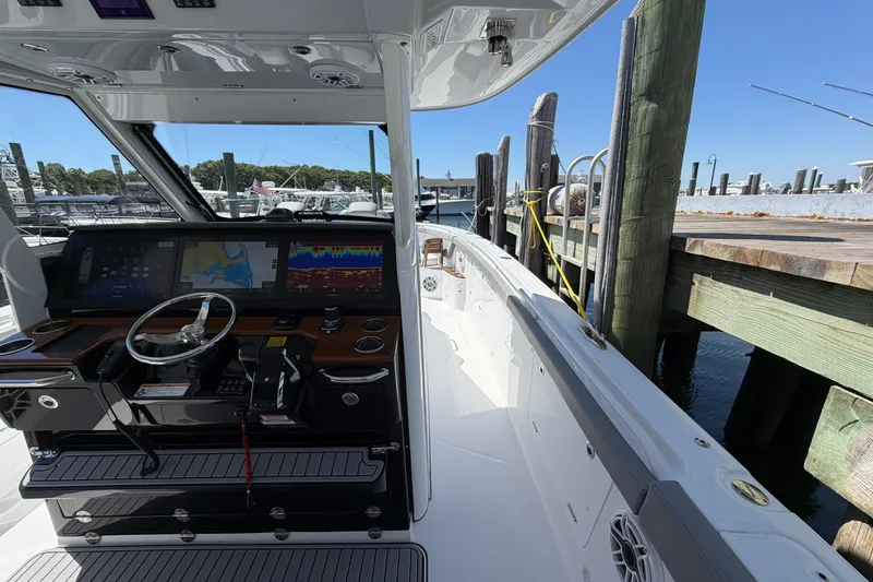 Slide: The Image of 2026 Everglades 395 Center Console boat docked, featuring advanced navigation systems and sleek design. - 69