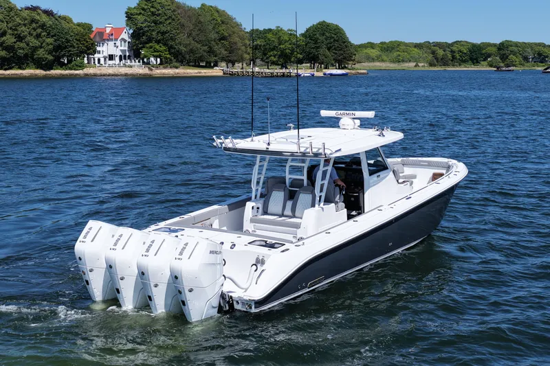 Slide: The Image of 2026 Everglades 395 Center Console boat cruising on a scenic lake. - 7