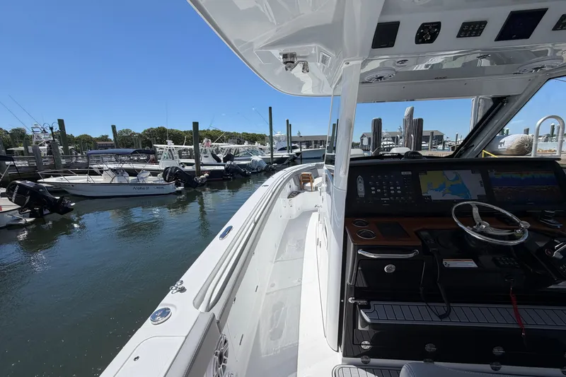 Slide: The Image of 2026 Everglades 395 Center Console boat docked at marina, featuring advanced navigation system. - 72
