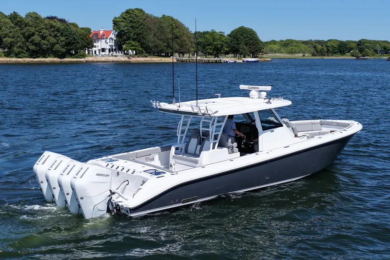 Slide: The Image of 2026 Everglades 395 Center Console boat cruising on a scenic lake. - 8