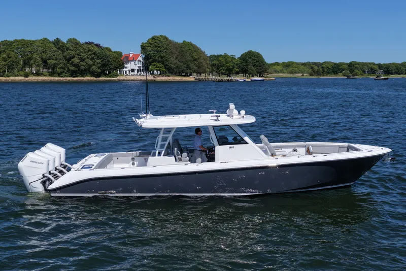 Slide: The Image of 2026 Everglades 395 Center Console boat cruising on a scenic lake. - 9