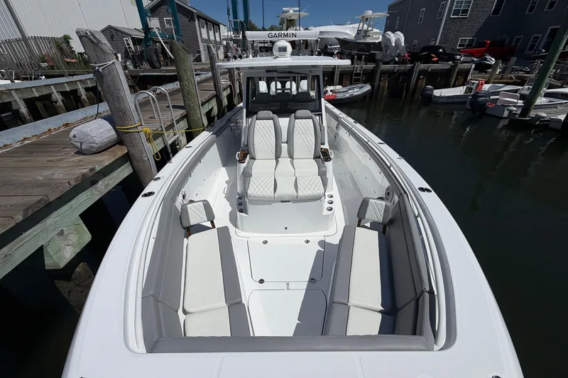 Slide: The Image of 2026 Everglades 395 Center Console boat docked at marina, showcasing sleek design and seating. - 90