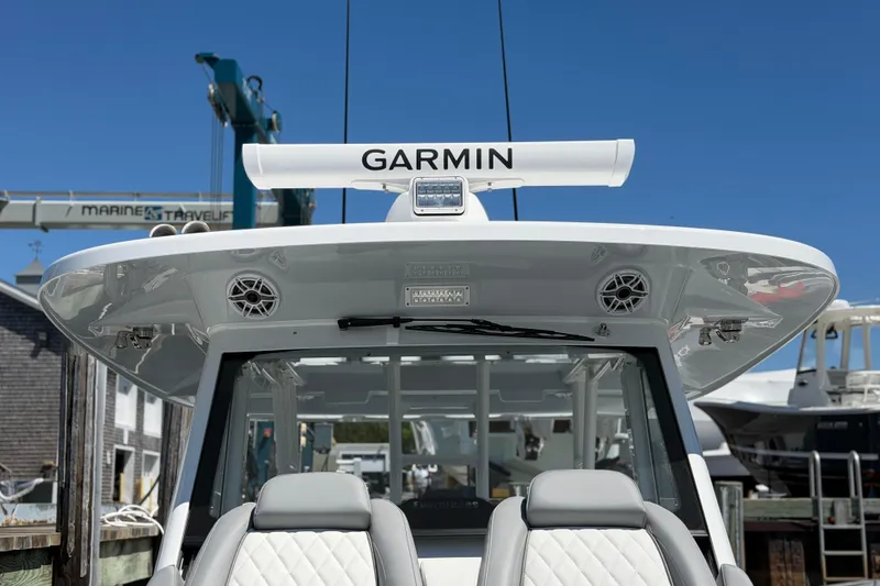 Slide: The Image of 2026 Everglades 395 Center Console boat with Garmin radar, docked under clear blue sky. - 93