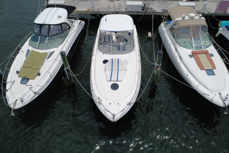 Slide: The Image of Three boats docked at a marina, featuring a 2006 Regal Commodore 3560. - 10