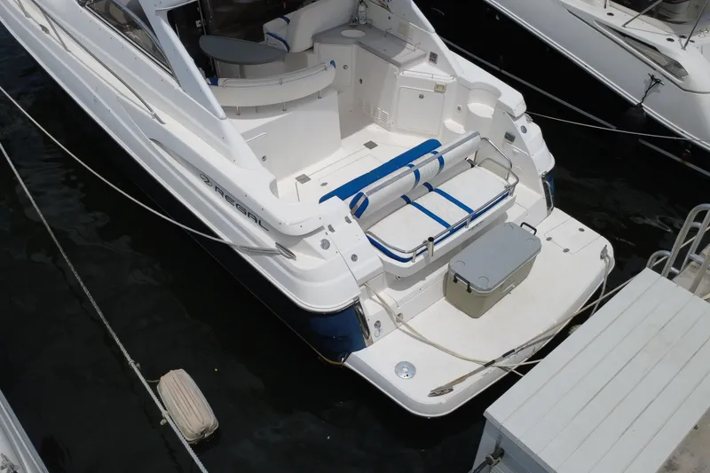 Slide: The Image of 2006 Regal Commodore 3560 yacht docked, featuring spacious seating and sleek design. - 4