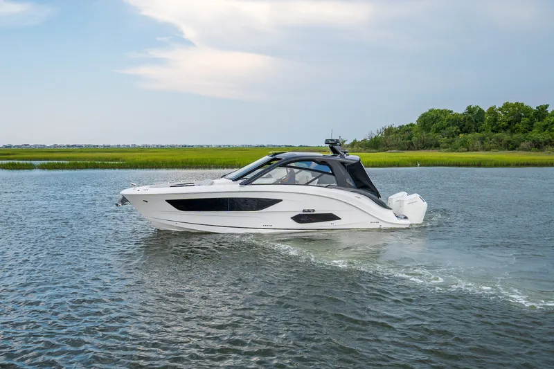 Slide: The Image of A sleek, modern boat cruising on calm waters, surrounded by green landscape. - 6