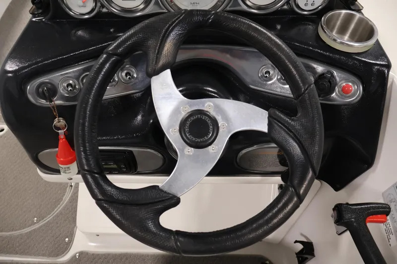 Slide: The Image of Steering wheel of 2015 Starcraft Star Step 220 I/O boat with dashboard controls. - 20