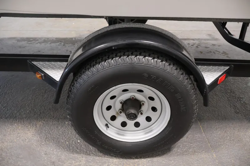 Slide: The Image of Trailer wheel of a 2015 Starcraft Star Step 220 I/O boat, featuring a black fender. - 48