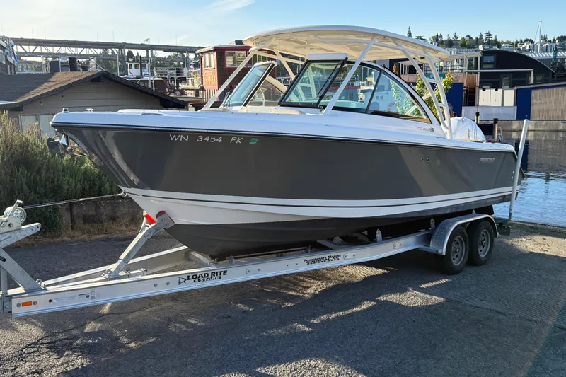Slide: The Image of 2016 Pursuit DC 265 Dual Console boat on trailer near waterfront. - 1