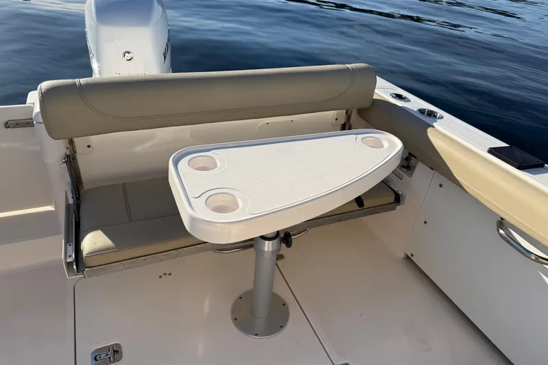 Slide: The Image of 2016 Pursuit DC 265 Dual Console boat interior with seating and table setup. - 11