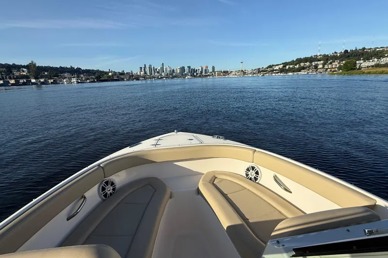 Slide: The Image of 2016 Pursuit DC 265 Dual Console boat cruising on a scenic urban waterway. - 17
