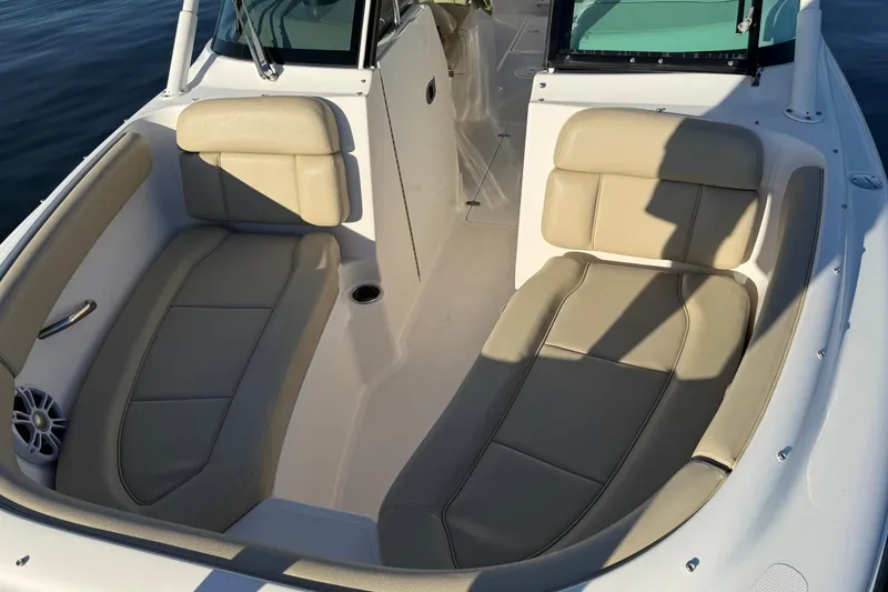 Slide: The Image of 2016 Pursuit DC 265 Dual Console boat interior with beige seating and cup holder. - 18