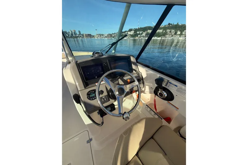 Slide: The Image of 2016 Pursuit DC 265 Dual Console boat helm with city skyline view. - 24
