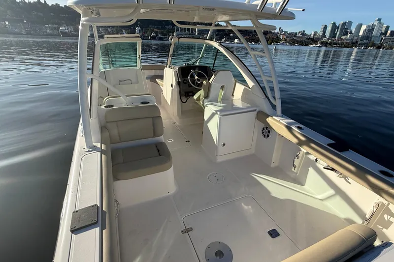 Slide: The Image of 2016 Pursuit DC 265 Dual Console boat interior on calm water with city skyline. - 5