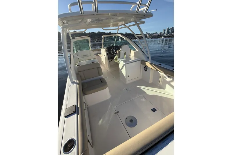 Slide: The Image of 2016 Pursuit DC 265 Dual Console boat interior with seating and helm, on calm water. - 6