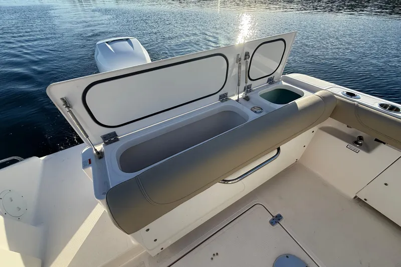 Slide: The Image of 2016 Pursuit DC 265 Dual Console boat with open storage compartment on calm water. - 8