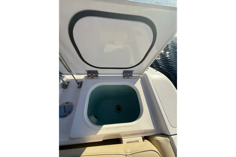 Slide: The Image of Open storage compartment on 2016 Pursuit DC 265 Dual Console boat. - 9