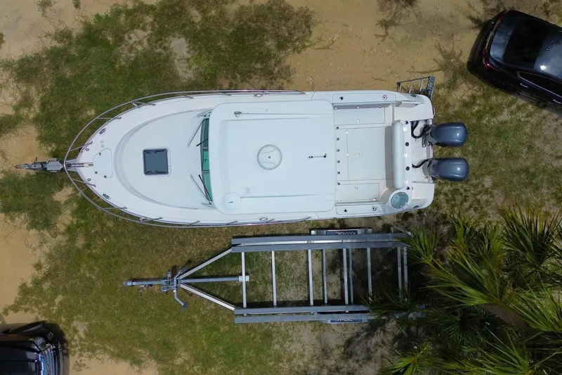 Slide: The Image of Overhead view of 2018 Robalo R305 Walkaround boat on trailer, parked on grass. - 6