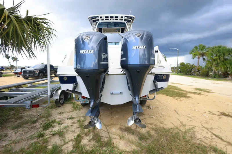 Slide: The Image of 2018 Robalo R305 Walkaround boat with dual Yamaha 300 engines on a sandy shore. - 7