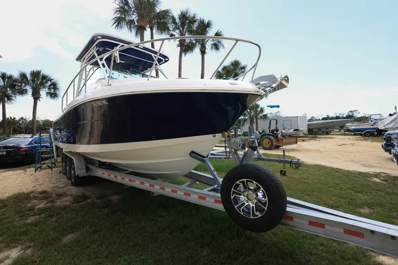 Slide: The Image of 2018 Robalo R305 Walkaround boat on trailer, parked outdoors with palm trees. - 8