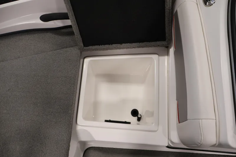 Slide: The Image of 2019 Nitro Z19 Sport boat storage compartment with open lid, featuring gray carpet and white interior. - 16