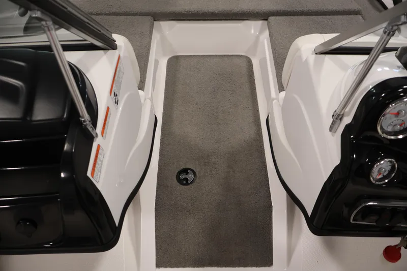 Slide: The Image of Interior view of a 2019 Nitro Z19 Sport boat, featuring gray carpet and dashboard controls. - 18