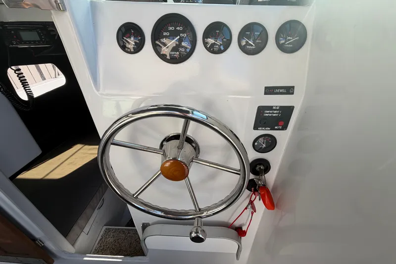 Slide: The Image of 1986 Radon 21 Sport boat dashboard with steering wheel and gauges. - 15