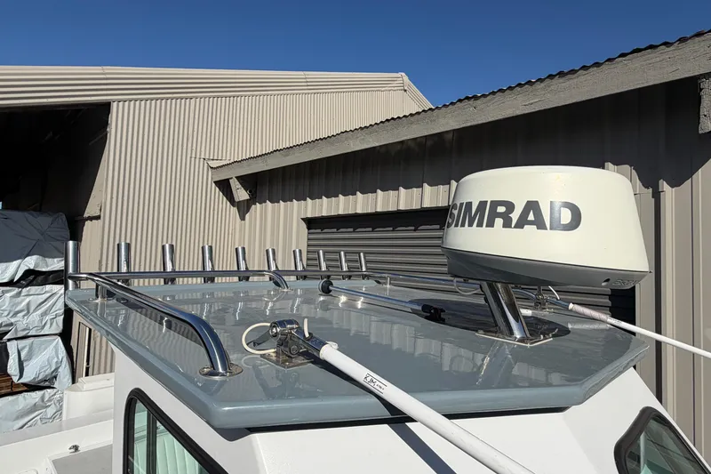 Slide: The Image of 1986 Radon 21 Sport boat with Simrad radar, parked near a corrugated metal building. - 17