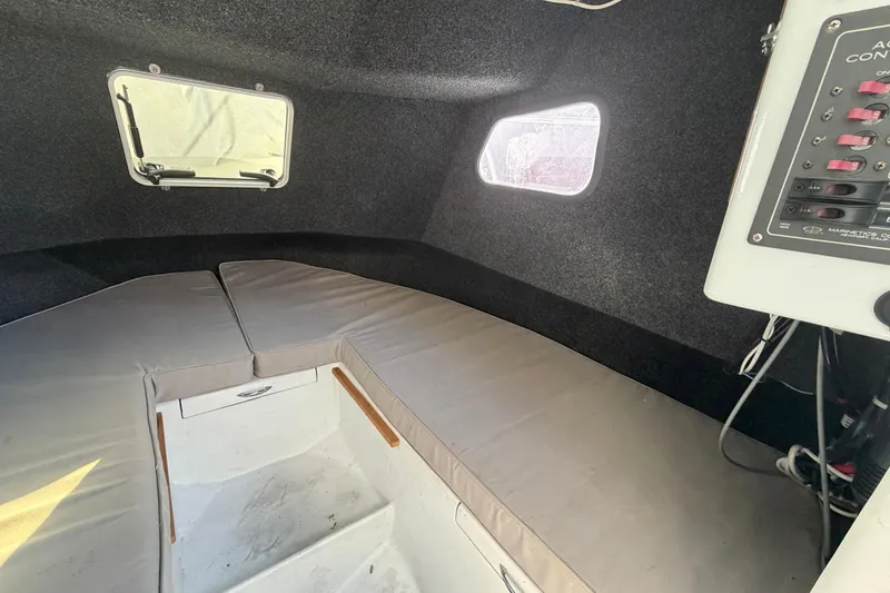 Slide: The Image of Interior cabin of a 1986 Radon 21 Sport boat with cushioned seating and control panel. - 21