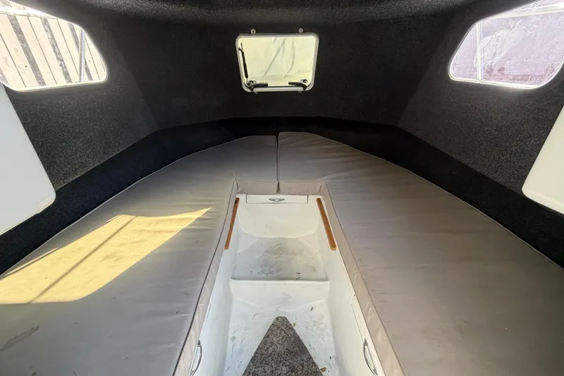 Slide: The Image of Interior cabin of a 1986 Radon 21 Sport boat, featuring cushioned seating and windows. - 23